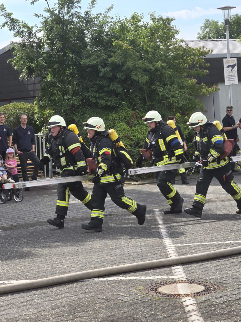 Mit vereinten Kräften und vollem Einsatz. Das eingespielte Team eilt im Laufschritt mit der Leiter zum Einsatzort, um in Sekundenschnelle Menschen aus Gefahr zu retten.